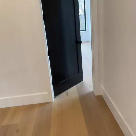 A black door in a white hallway