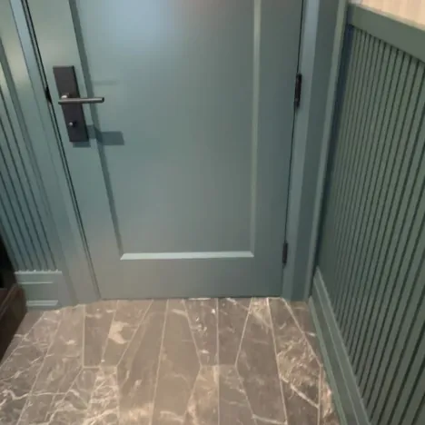 A green door and paneled wall
